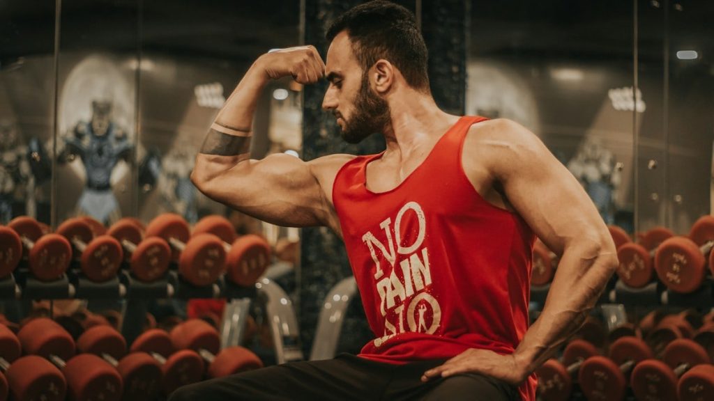 man in red tank top sitting on chair